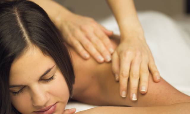 Frau erhält Nackenmassage